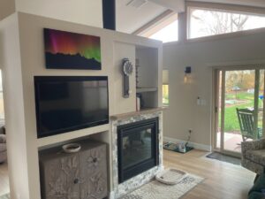 Finished garage conversion living area with fireplace and glass doors